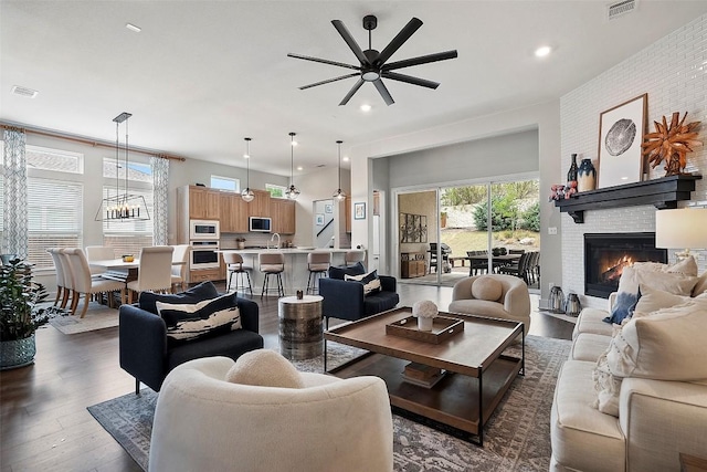 living room with visible vents, a ceiling fan, and a wealth of natural light