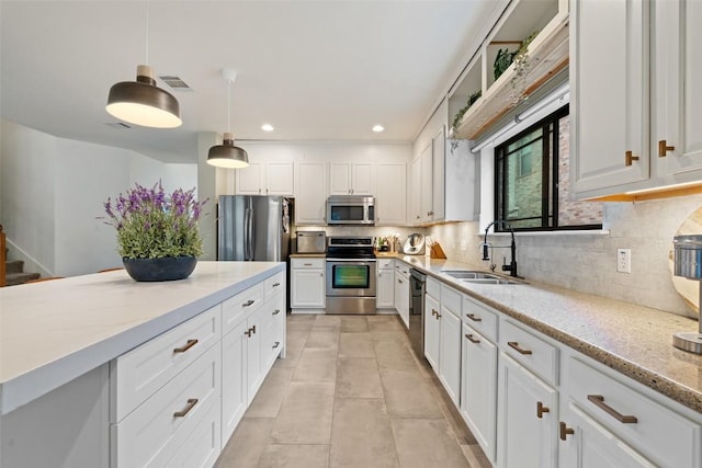 kitchen featuring visible vents, a sink, appliances with stainless steel finishes, and backsplash