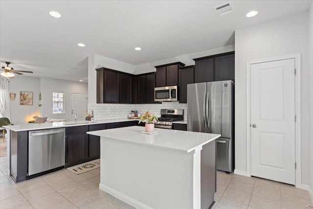 kitchen featuring a ceiling fan, light tile patterned floors, visible vents, a sink, and stainless steel appliances