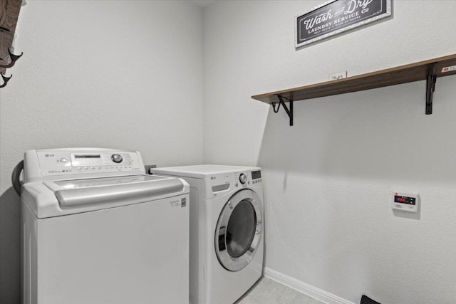 laundry area featuring baseboards, laundry area, and washer and clothes dryer