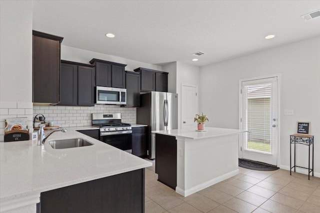 kitchen with decorative backsplash, stainless steel appliances, visible vents, and a sink