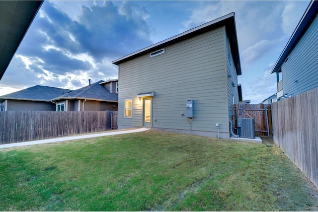 back of house featuring a yard, a fenced backyard, and cooling unit