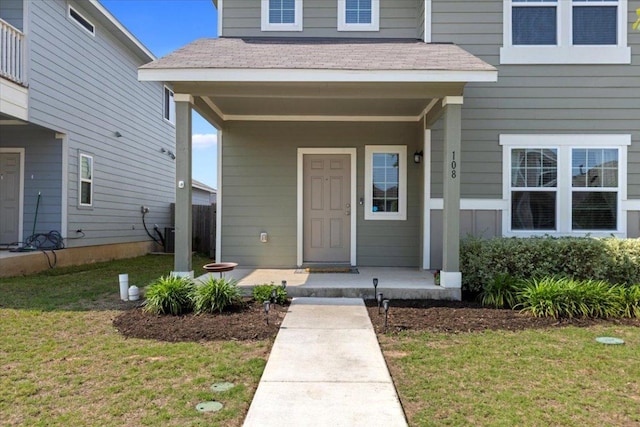 property entrance featuring a yard and covered porch