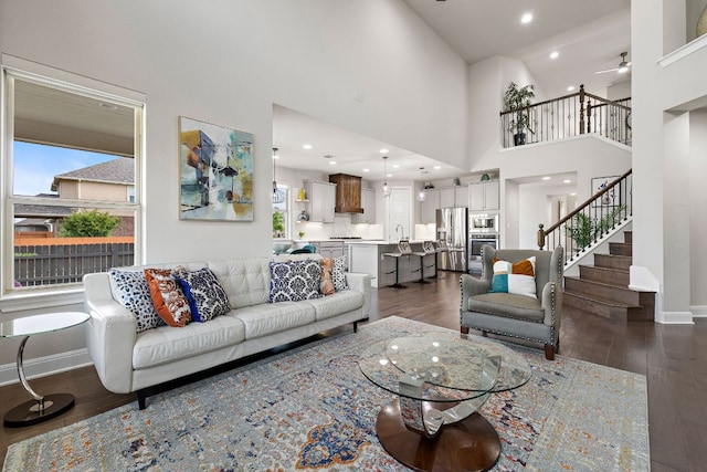 800 Kenney Fort Xing, Round Rock, TX 78665 - living area with healthy amount of natural light, dark wood-style flooring, stairway, a ceiling fan, and a high ceiling