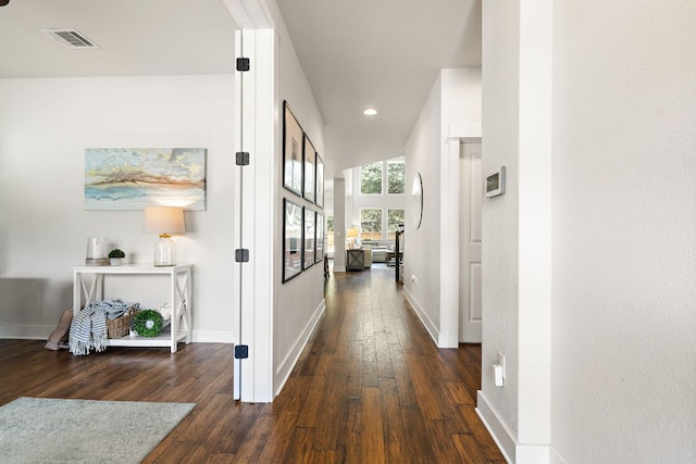 hall with baseboards, recessed lighting, wood finished floors, and visible vents