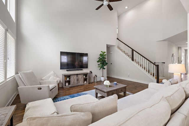 living area with stairs, a high ceiling, and a wealth of natural light