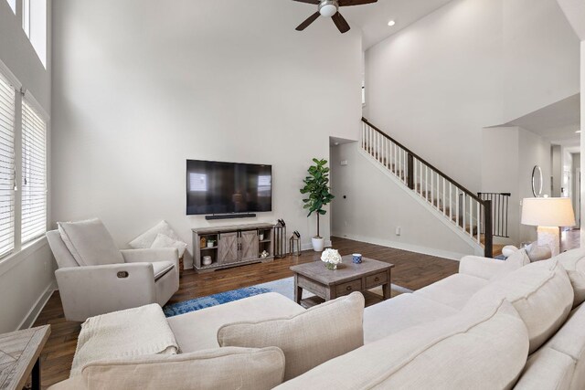 1403 Matthews Ln, Austin, TX 78745 - living room featuring a high ceiling, healthy amount of natural light, stairway, ceiling fan, and wood finished floors