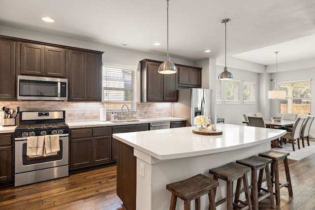 kitchen featuring a sink, dark wood finished floors, appliances with stainless steel finishes, and dark brown cabinets