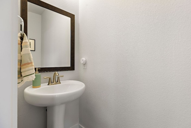 bathroom with a sink and a textured wall