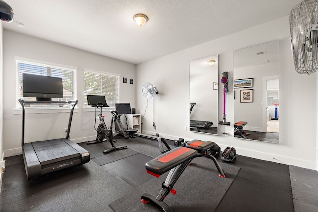 exercise area featuring baseboards and visible vents