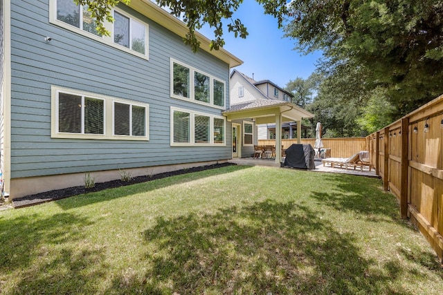 rear view of house featuring fence, a patio, and a yard