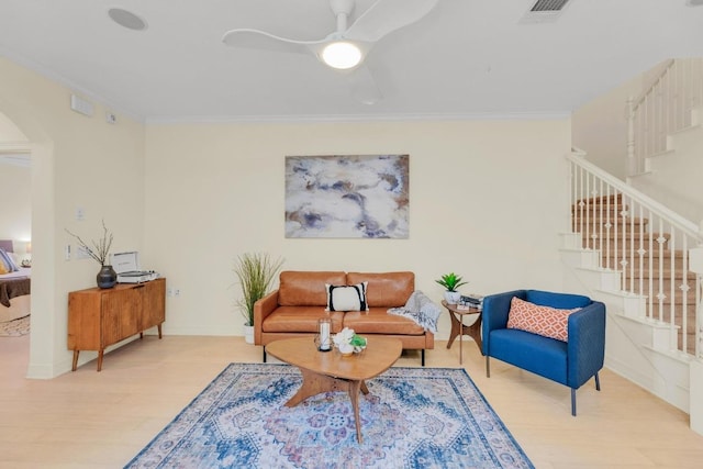 sitting room featuring ornamental molding, stairs, arched walkways, and wood finished floors