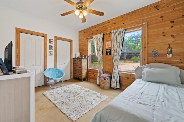 9854 N Weir Loop Cir, Austin, TX 78736 - bedroom with two closets, a ceiling fan, and wood walls