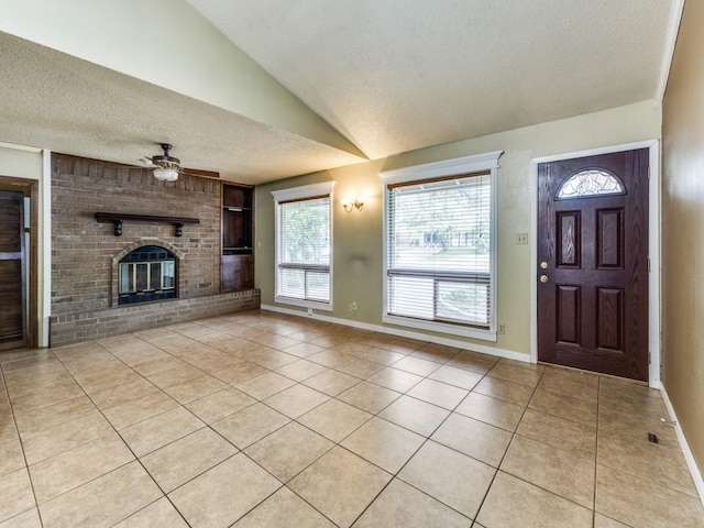 817 Glen Oak Dr, Austin, TX 78745 - foyer entrance with light tile patterned floors, a textured ceiling, ceiling fan, a brick fireplace, and vaulted ceiling