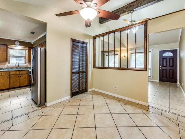 foyer featuring ceiling fan, visible vents, beam ceiling, light tile patterned floors, and baseboards