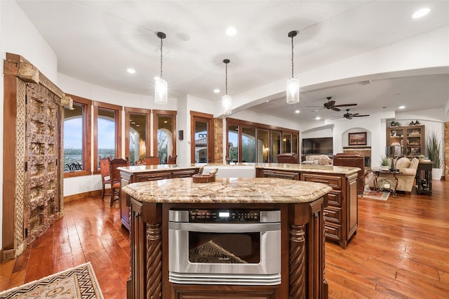 kitchen featuring open floor plan, ceiling fan, a spacious island, recessed lighting, and hardwood / wood-style flooring