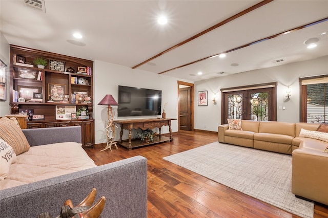 living area featuring visible vents and wood finished floors