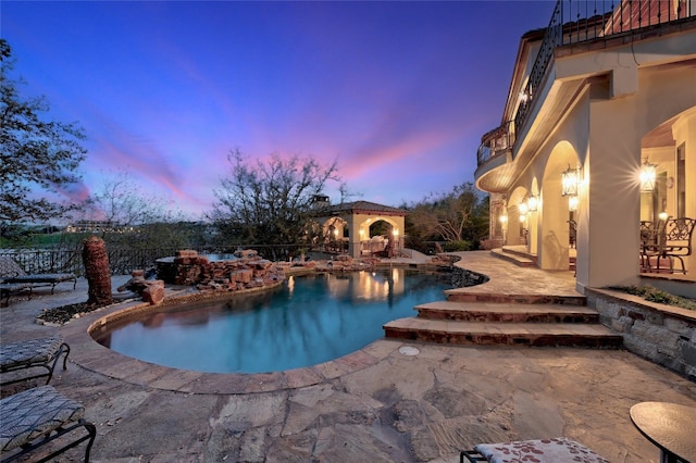 pool at dusk with a fenced in pool, fence, and a patio area