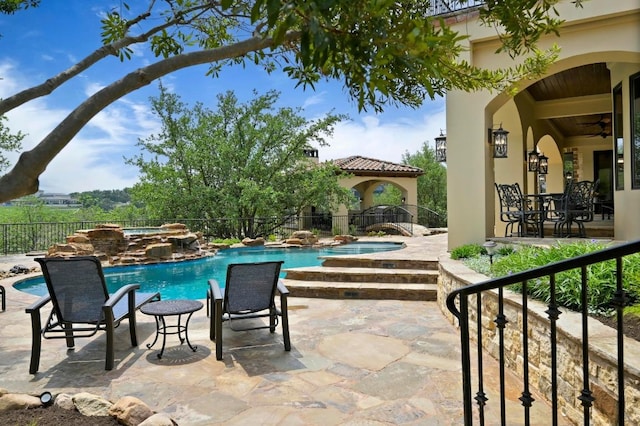 view of patio / terrace featuring an in ground hot tub, a ceiling fan, a gazebo, fence, and a fenced in pool