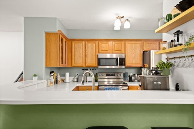 6900 E Riverside Dr Unit 17, Austin, TX 78741 - kitchen with stainless steel appliances, open shelves, a peninsula, glass insert cabinets, and a kitchen bar