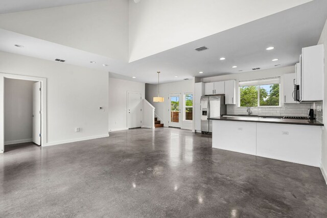 unfurnished living room featuring concrete floors, recessed lighting, baseboards, visible vents, and stairway