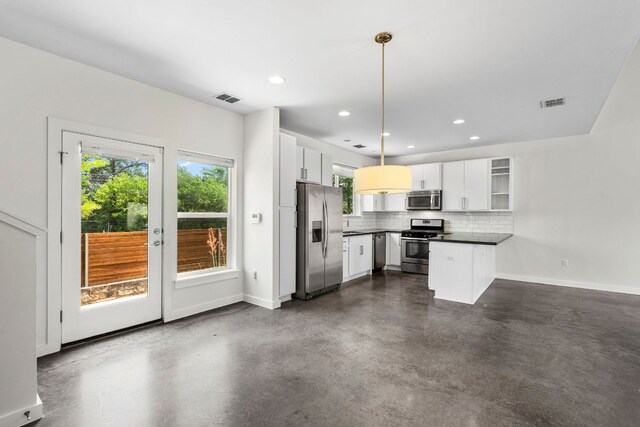 kitchen with stainless steel appliances, visible vents, plenty of natural light, and a peninsula