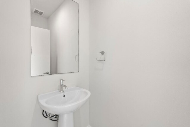 bathroom with visible vents, a sink, and baseboards