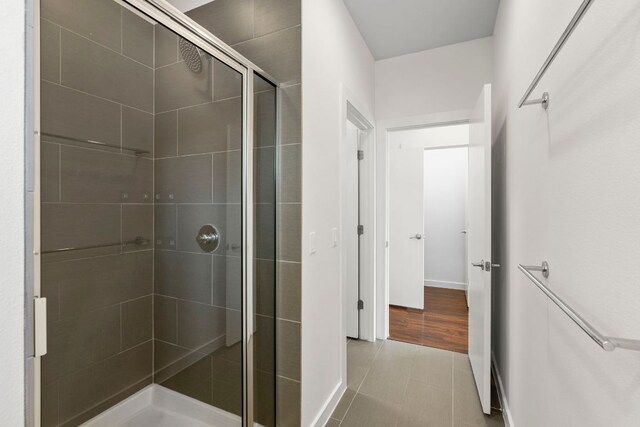 bathroom with baseboards and a stall shower