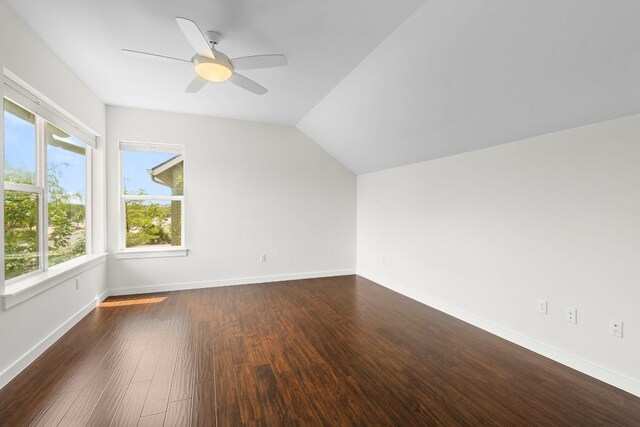 additional living space featuring baseboards, a ceiling fan, dark wood-style floors, and lofted ceiling