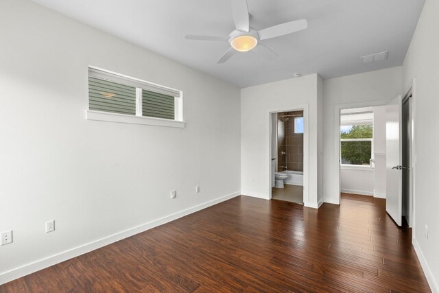 unfurnished bedroom featuring a ceiling fan, baseboards, wood finished floors, ensuite bathroom, and visible vents