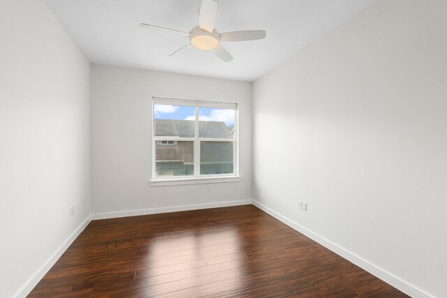 spare room with baseboards, ceiling fan, and wood finished floors