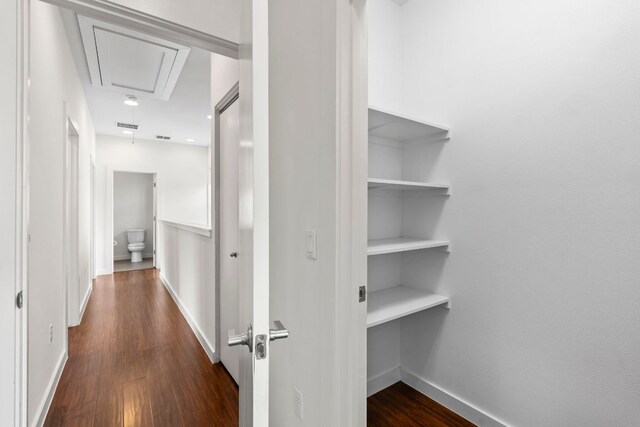 hall featuring baseboards, attic access, dark wood-style floors, and visible vents