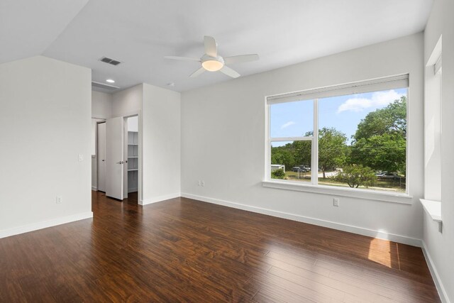 interior space with baseboards, a ceiling fan, wood finished floors, and visible vents