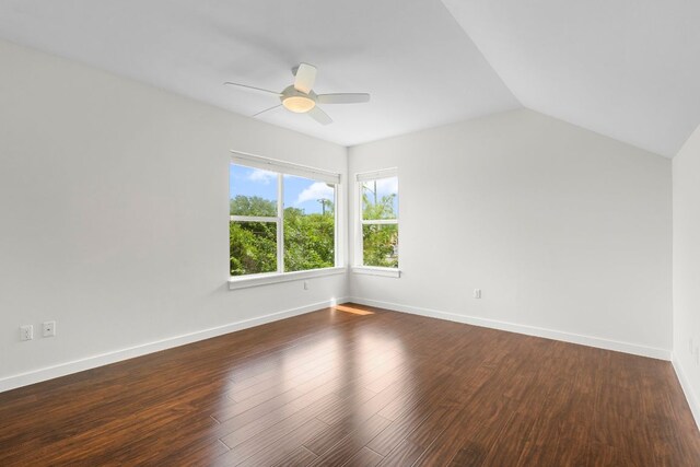 empty room featuring baseboards, a ceiling fan, wood finished floors, and vaulted ceiling