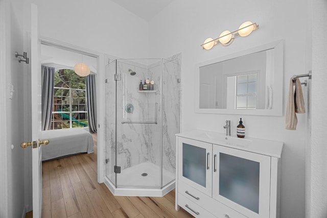 full bath featuring vanity, a marble finish shower, ensuite bathroom, and wood finished floors