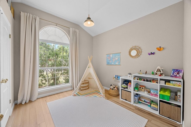 rec room with baseboards, vaulted ceiling, and wood finished floors