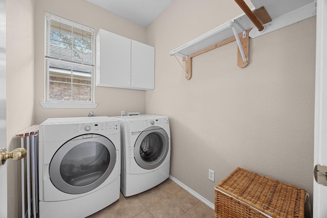 clothes washing area with cabinet space, baseboards, washing machine and dryer, and light tile patterned floors