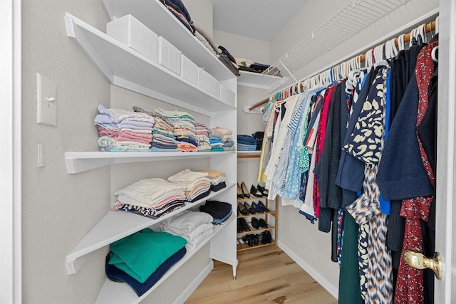 walk in closet with wood finished floors
