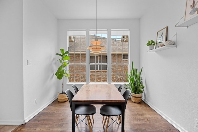 dining area with baseboards and wood finished floors