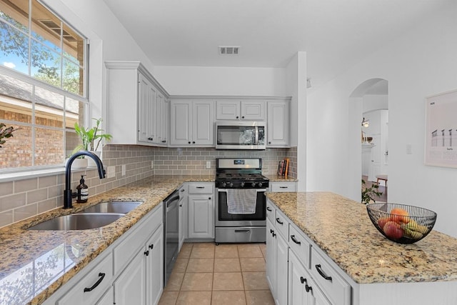 kitchen featuring a sink, tasteful backsplash, stainless steel appliances, and visible vents