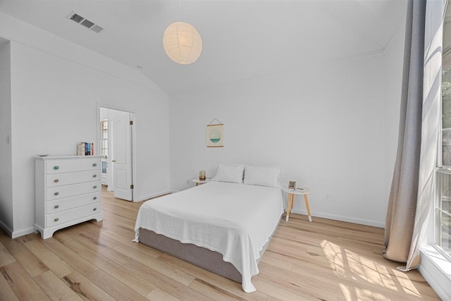 bedroom featuring baseboards, visible vents, vaulted ceiling, and light wood-type flooring