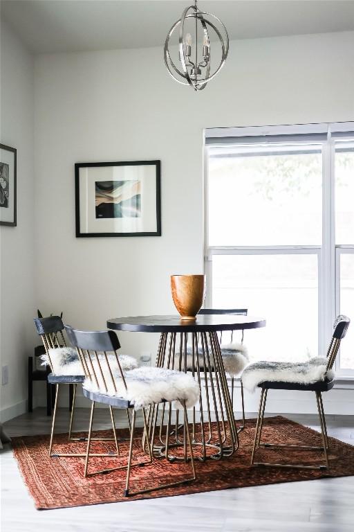 dining area featuring an inviting chandelier, wood finished floors, and a healthy amount of sunlight