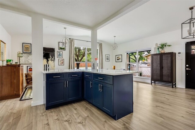 kitchen with light countertops, blue cabinetry, an inviting chandelier, and light wood-type flooring