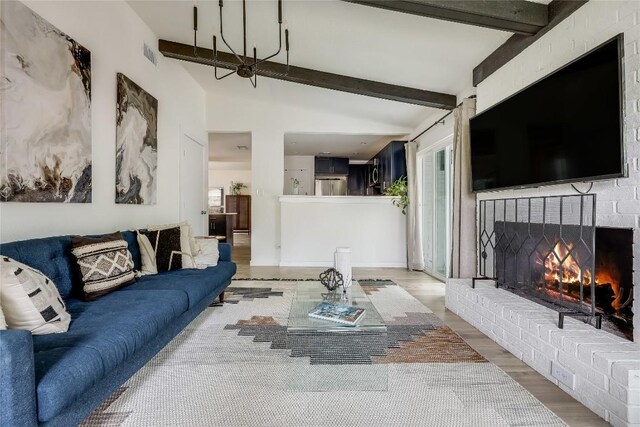 living room with vaulted ceiling with beams, a fireplace, wood finished floors, and visible vents