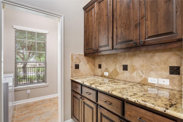 2420 Champions Corner Dr, Leander, TX 78641 - kitchen with washer / clothes dryer, tasteful backsplash, healthy amount of natural light, and light stone countertops