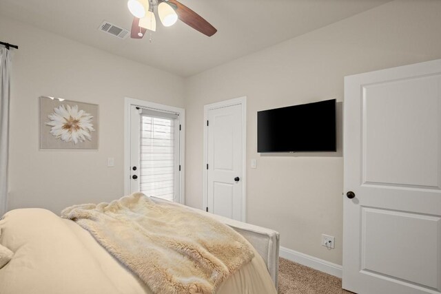 bedroom featuring visible vents, baseboards, ceiling fan, and light carpet