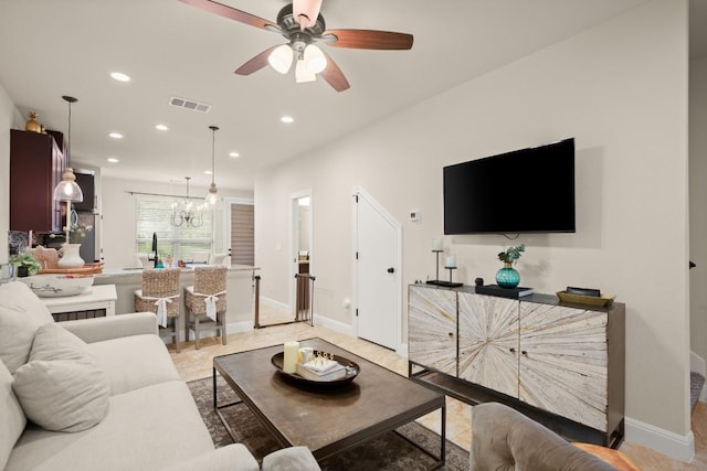 living area with visible vents, recessed lighting, baseboards, and ceiling fan with notable chandelier
