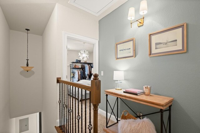 hall featuring baseboards, carpet floors, and an upstairs landing