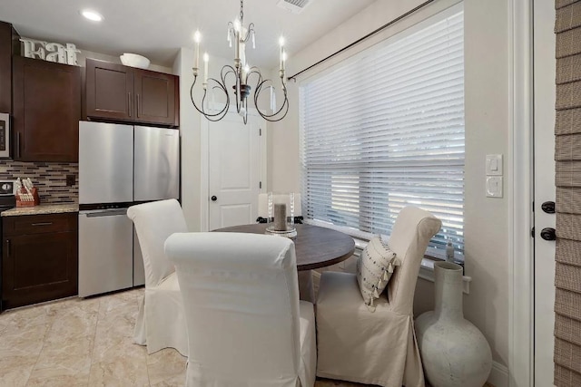 dining room featuring an inviting chandelier and visible vents