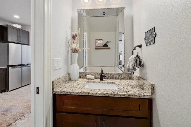 bathroom featuring vanity and a textured wall